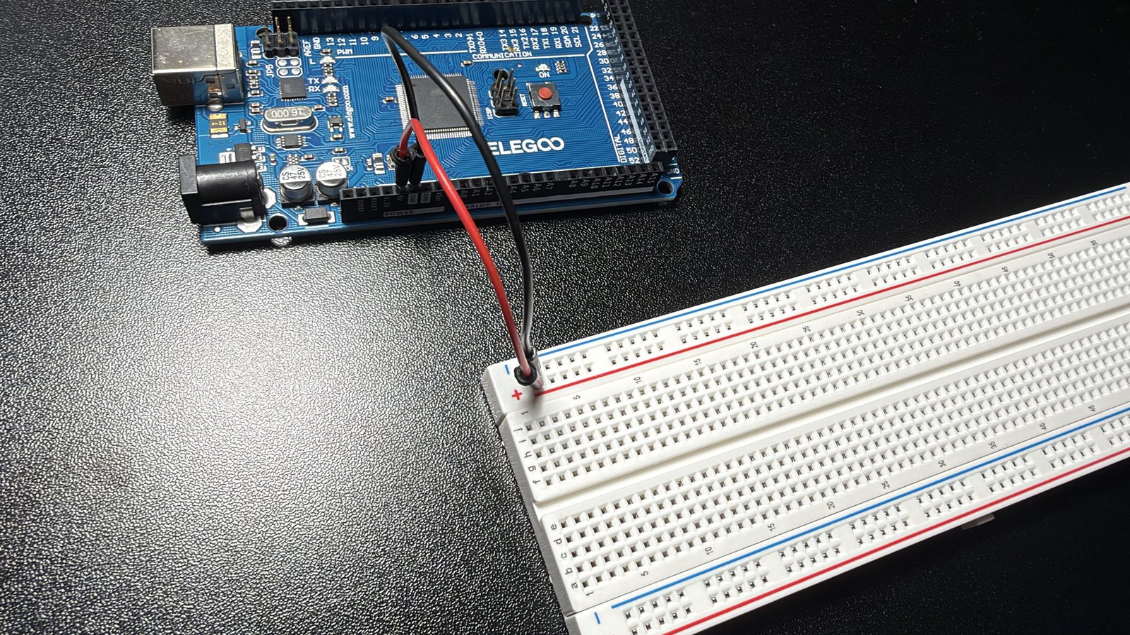 The breadboard power rails fed by one 5 V and one ground wire from the Mega